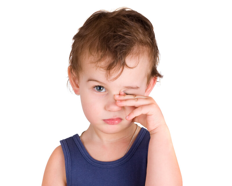 Common causes of eye pain: A little boy rubbing eyes