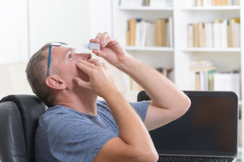 dry eye prevention and treatment: man applying eye drops